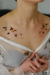 Scattered small floral tattoo across the collarbone