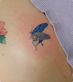 Watercolor blue butterfly tattoo on the shoulder