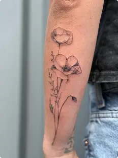 Fine-line poppy flowers tattoo on the forearm
